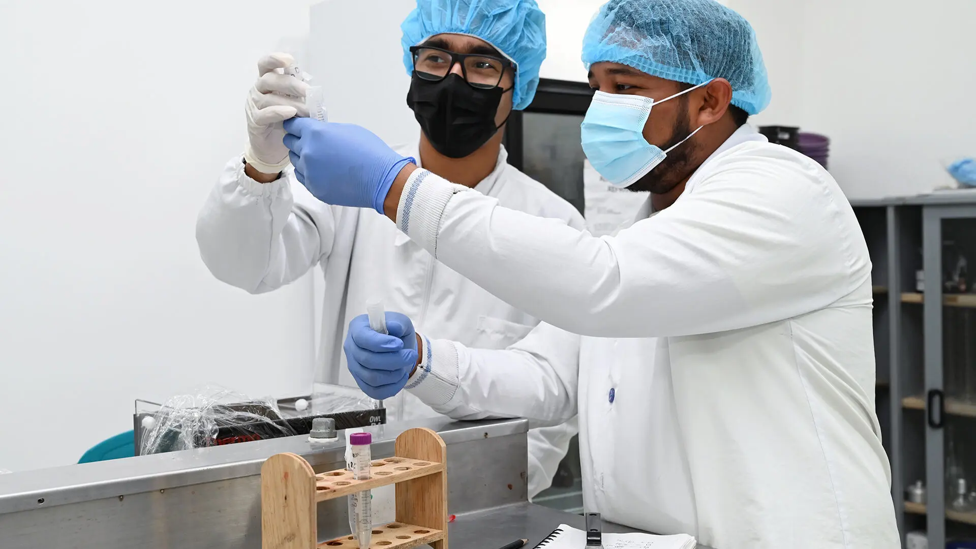 Estudiantes de Biología en laboratorio de la Universidad de La Guajira explorando experimentos con entusiasmo y dedicación.