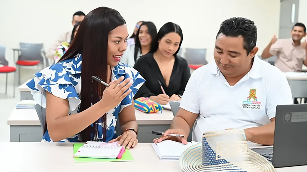 Un joven y una mujer estudiando juntos en un salón de clases.