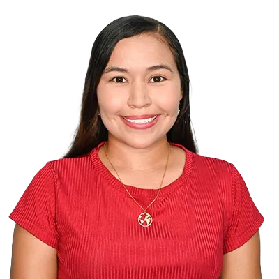 Maryuris Ortega Pérez Asesora de internacionalización curricular de la facultad de ciencias económicas y administrativas, Retrato de una mujer sonriente con cabello oscuro y liso, vistiendo una camiseta roja de cuello redondo con textura acanalada y un collar dorado con un colgante en forma de globo terráqueo, sobre un fondo blanco liso.