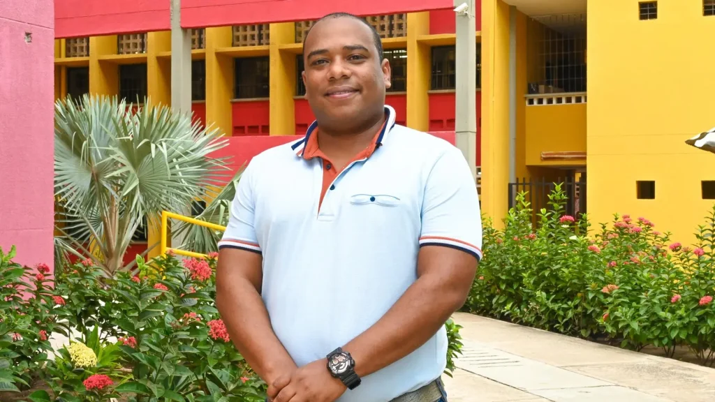 Hombre de tez morena sonriente ante una cámara