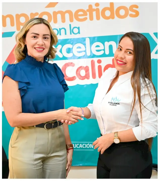Dos mujeres dándose las manos mientras posan para la foto.