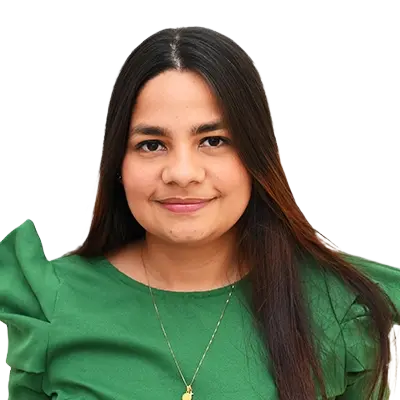 Surisaday Gutierrez Alturo Directora del Programa de Medicina, joven de cabello largo y lacio, viste una blusa verde con mangas abullonadas y un collar dorado. Está de pie frente a un fondo blanco, mirando a la cámara con una expresión serena y una leve sonrisa.