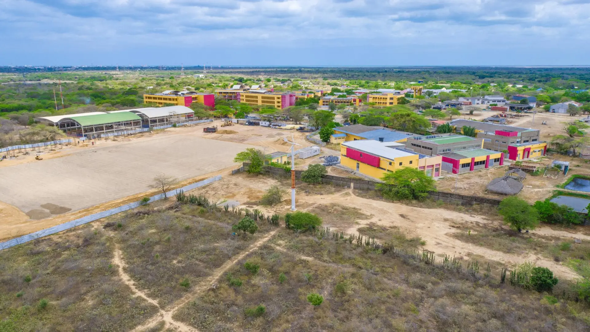 Vista panorámica de la Universidad de La Guajira, se observan las comunidades aledañas, el aerogenerador y el campus