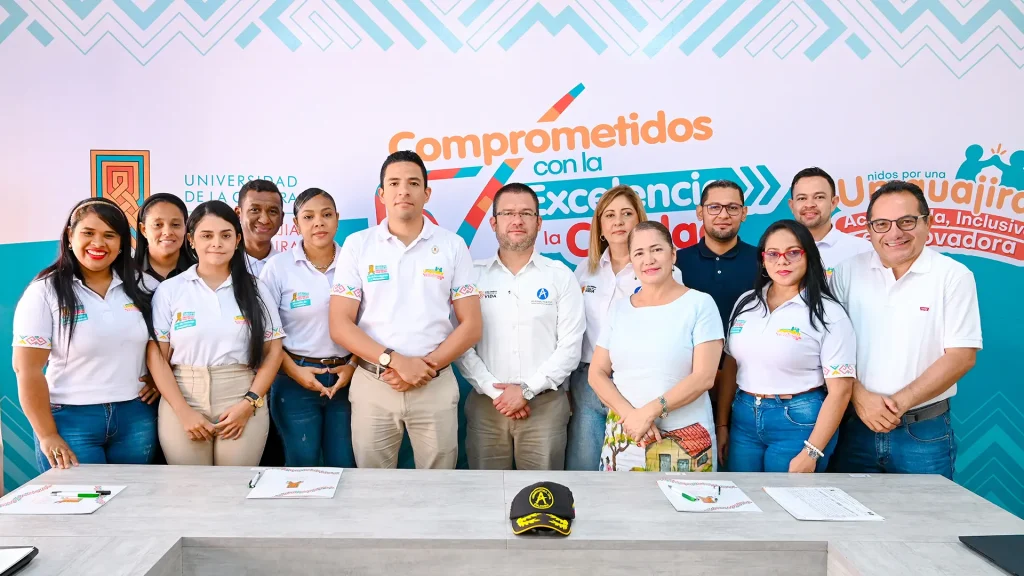 Grupo de mujeres y hombres adultos pertenecientes a Uniguajira y la Aeronáutica Civil posando para una foto