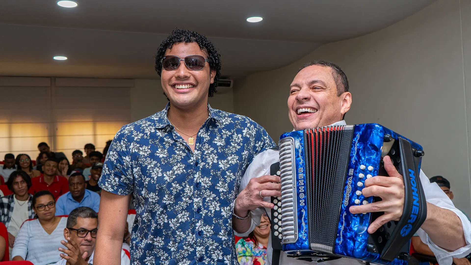El Cocha Molina y un estudiante del programa de Licenciatura en Música de Uniguajira sonríen juntos.