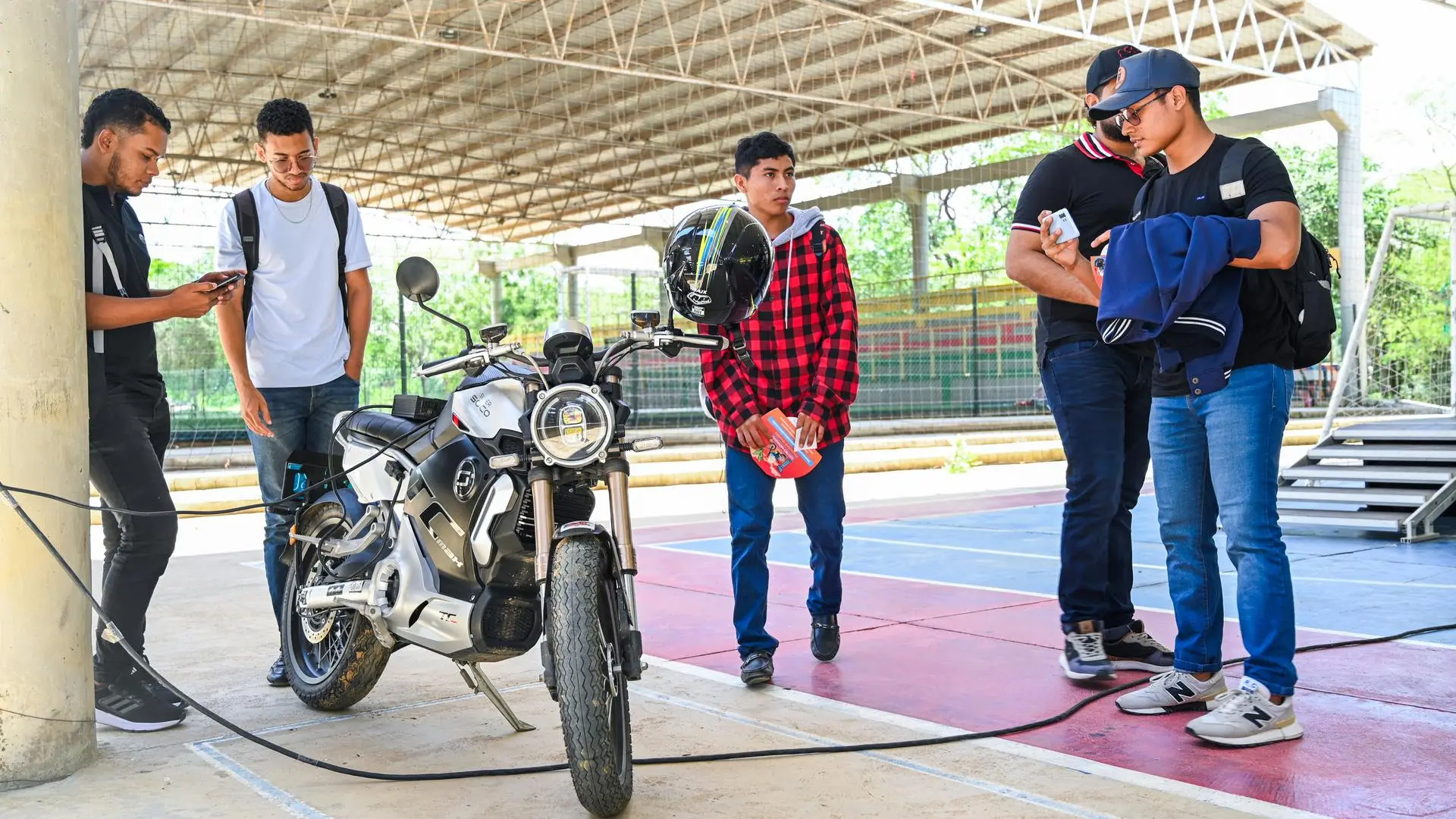 cinco jovenes mirando una moto