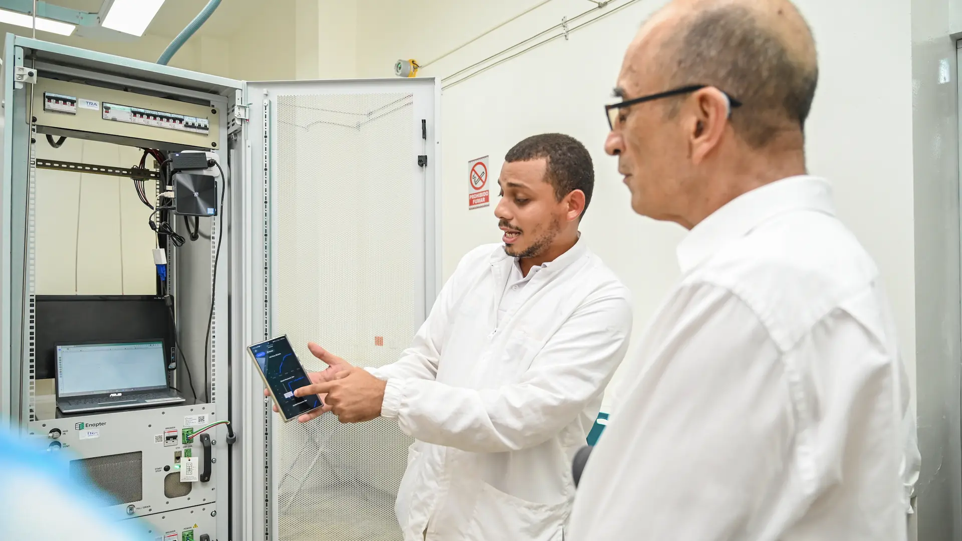 Marlon Córdoba Ramírez, docente de Ingeniería Mecánica y Germán Moreno Ospina, par académico en la Planta Piloto Power to Gas, utilizando el equipo electrolizador para la generación de hidrógeno verde.