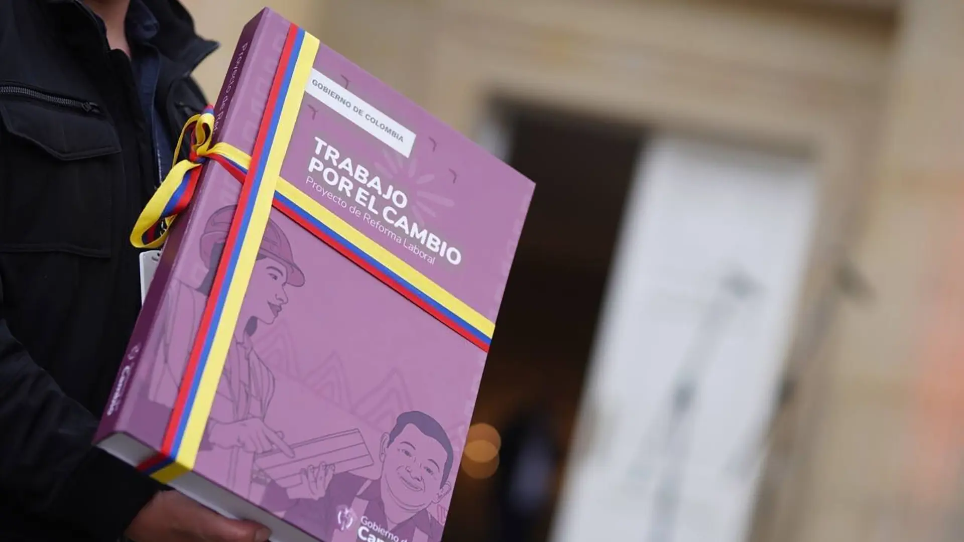 Un grupo de nueve personas, compuesto por hombres y mujeres, posa sonriente en el interior del Centro de Innovación y Emprendimiento (CIE La Guajira). Están sentados y de pie sobre una banca curva, con mesas pequeñas frente a ellos. Al fondo se observa el logo del CIE en la pared.