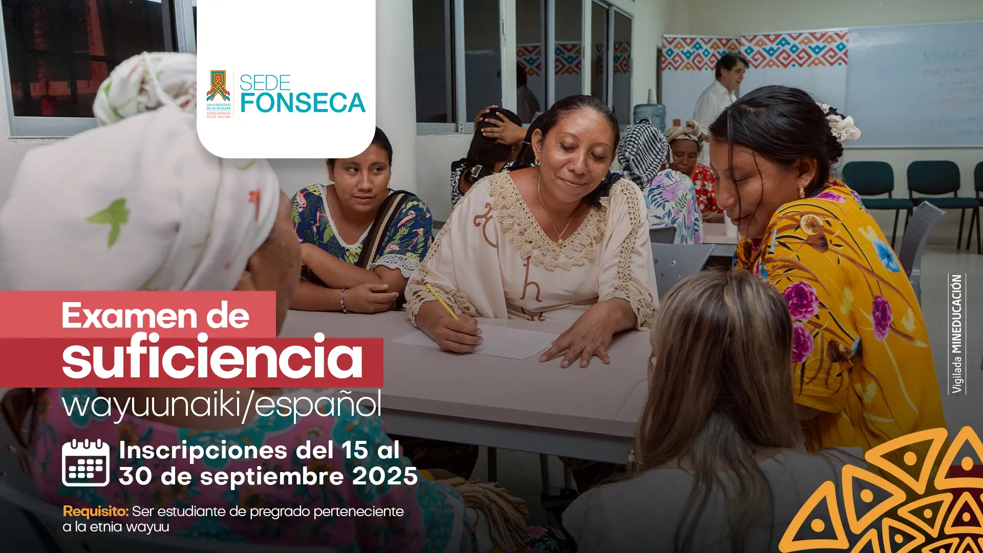 Un grupo de mujeres wayuu, algunas con mantas coloridas, están sentadas alrededor de una mesa en un salón de clases, mientras una de ellas escribe en una hoja con lápiz. En la parte superior izquierda aparece el logo de la Universidad de La Guajira, Sede Fonseca. El afiche anuncia el Examen de suficiencia wayuunaiki/español, con inscripciones del 15 al 30 de septiembre de 2025, dirigido a estudiantes de pregrado pertenecientes a la etnia wayuu.