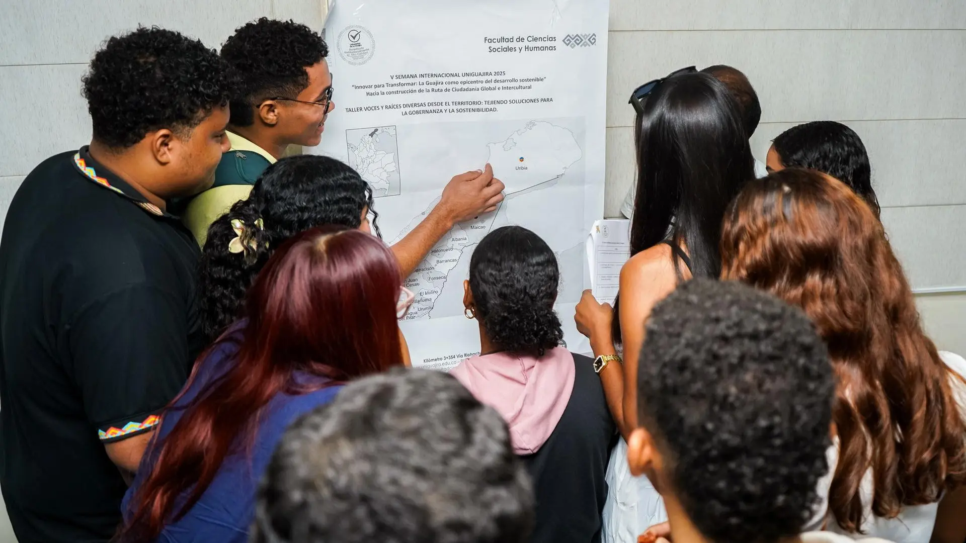 Estudiantes de la Universidad de La Guajira participan en un taller colaborativo durante la V Semana Internacional Uniguajira 2025, analizando un mapa territorial como parte de la actividad “Voces y raíces diversas del territorio