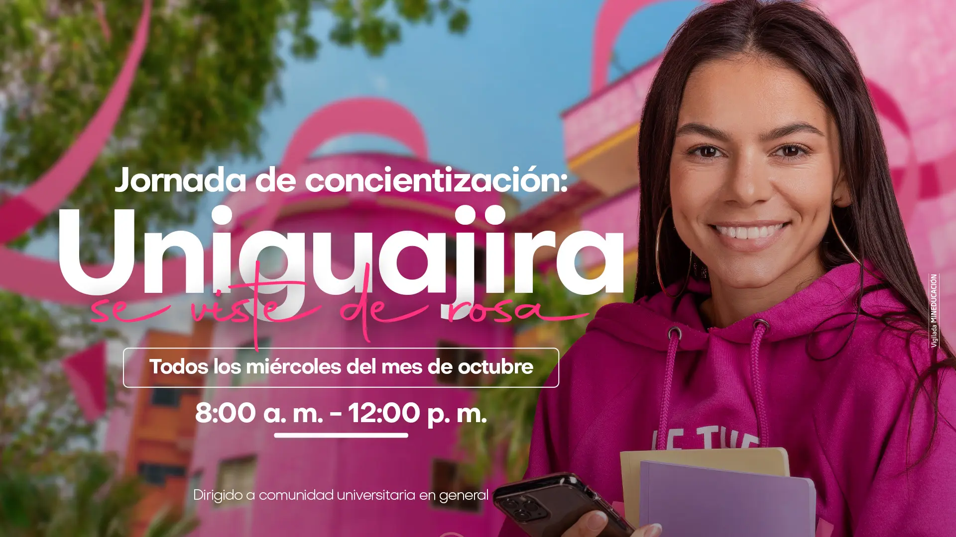 Imagen promocional de la campaña “Uniguajira se viste de rosa”. En el lado derecho aparece una joven sonriente, con sudadera rosada y cuadernos en la mano. Al fondo, se observa un edificio de la Universidad de La Guajira iluminado con tonos rosados y decorado con lazos alusivos a la lucha contra el cáncer de mama. En el centro de la pieza se lee: “Jornada de concientización: Uniguajira se viste de rosa. Todos los miércoles del mes de octubre, 8:00 a. m. – 12:00 p. m. Dirigido a la comunidad universitaria en general”