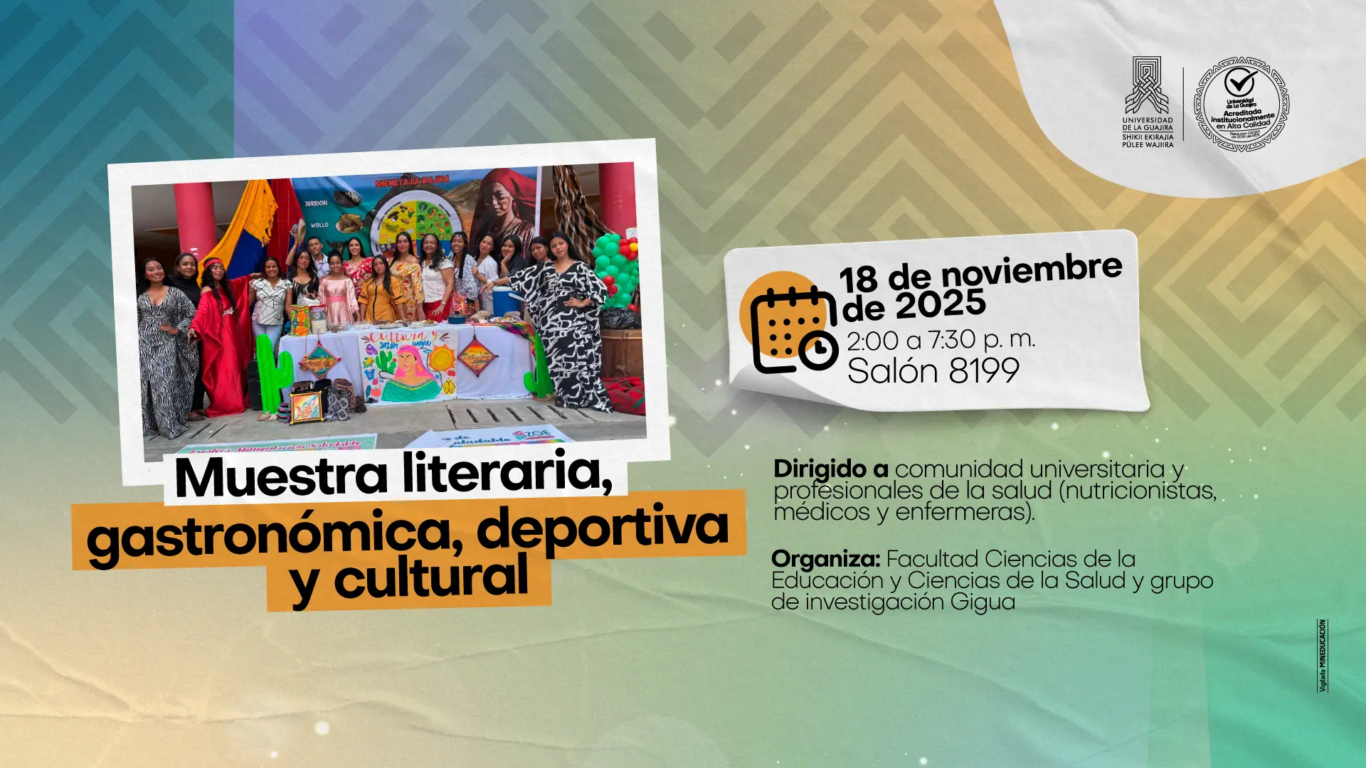 Grupo de estudiantes y docentes posan sonrientes detrás de una mesa decorada con elementos culturales y artesanales coloridos, como tejidos, pinturas y figuras representativas de la región. Visten atuendos variados, algunos tradicionales. A un costado hay globos y, al fondo, afiches con ilustraciones culturales. La imagen hace parte de una muestra literaria, gastronómica, deportiva y cultural organizada por la Universidad de La Guajira.