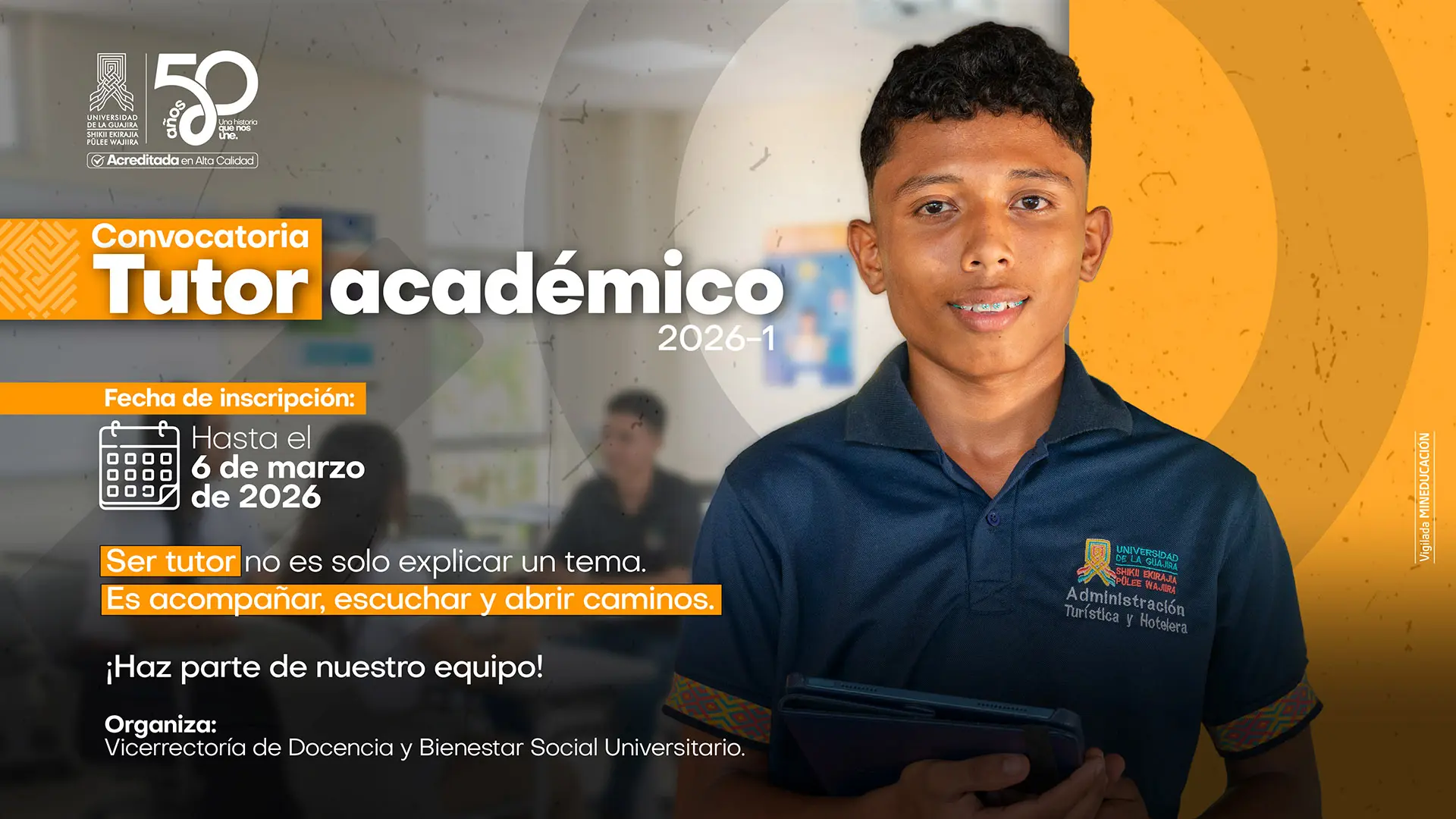 Afiche institucional de la Universidad de La Guajira que anuncia la “Convocatoria Tutor Académico 2026-1”. En la imagen aparece un estudiante joven con uniforme institucional azul oscuro del programa Administración Turística y Hotelera, sosteniendo una tablet y sonriendo frente a un salón de clases desenfocado. El diseño usa tonos naranja y gris e incluye el mensaje: “Fecha de inscripción: hasta el 6 de marzo de 2026”, “Ser tutor no es solo explicar un tema. Es acompañar, escuchar y abrir caminos” y “¡Haz parte de nuestro equipo!”. Organiza la Vicerrectoría de Docencia y Bienestar Social Universitario. En la parte superior se observa el logo de la Universidad de La Guajira y la conmemoración de 50 años, acreditada en alta calidad.