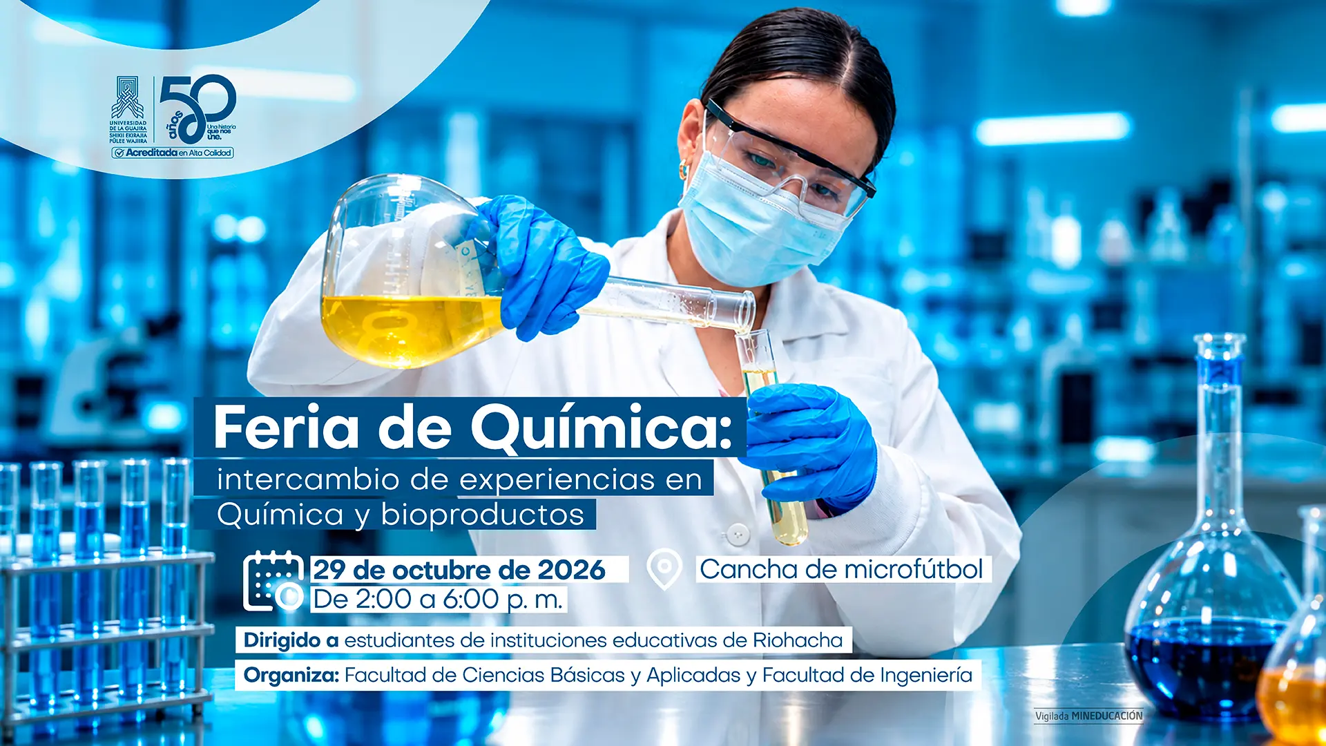 Afiche promocional de la Feria de Química, con una fotografía de una científica usando bata, gafas de seguridad, tapabocas y guantes azules mientras manipula líquidos en un laboratorio. El diseño, en tonos azules, muestra tubos de ensayo y matraces con sustancias químicas. El texto principal anuncia: “Feria de Química: intercambio de experiencias en Química y bioproductos”. El evento se realizará el 29 de octubre de 2026, de 2:00 a 6:00 p. m., en la Cancha de microfútbol. Está dirigido a estudiantes de instituciones educativas de Riohacha y es organizado por la Facultad de Ciencias Básicas y Aplicadas y la Facultad de Ingeniería. En la parte superior aparece un logotipo conmemorativo de 50 años
