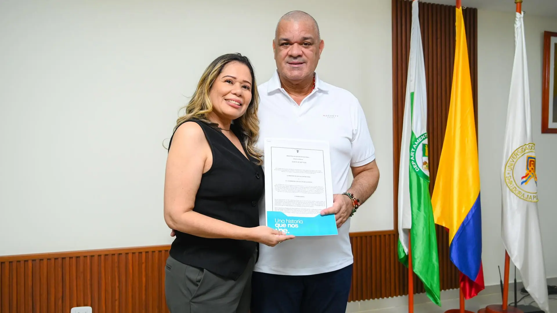 El rector y la directora del programa, exhiben la resolución que oficializa la renovación de la Acreditación en Alta Calidad otorgada por el MEN.